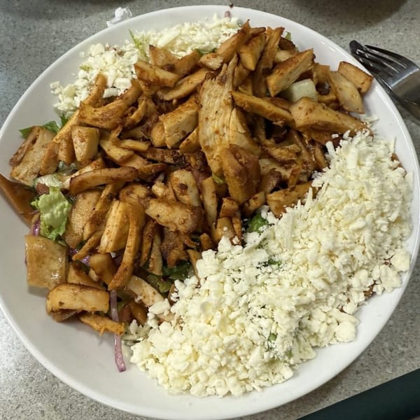 A LaVie Mediterranean Grill dish with seasoned chicken, lettuce, and crumbled feta cheese.