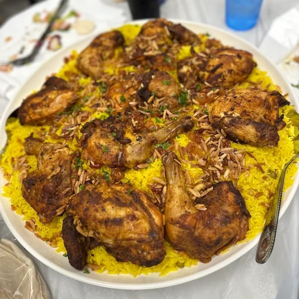 A large platter of LaVie Mediterranean Grill's roasted chicken pieces on a bed of yellow rice.